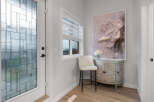 Step into a welcoming entryway featuring a decorative glass door and a stylish bar stool.