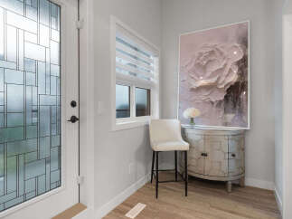 Step into a welcoming entryway featuring a decorative glass door and a stylish bar stool.