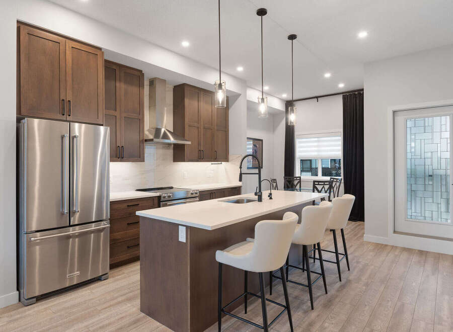 Experience modern living in this stunning kitchen, featuring rich wood cabinetry and sleek stainless steel appliances.
