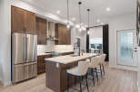 Experience modern living in this stunning kitchen, featuring rich wood cabinetry and sleek stainless steel appliances.