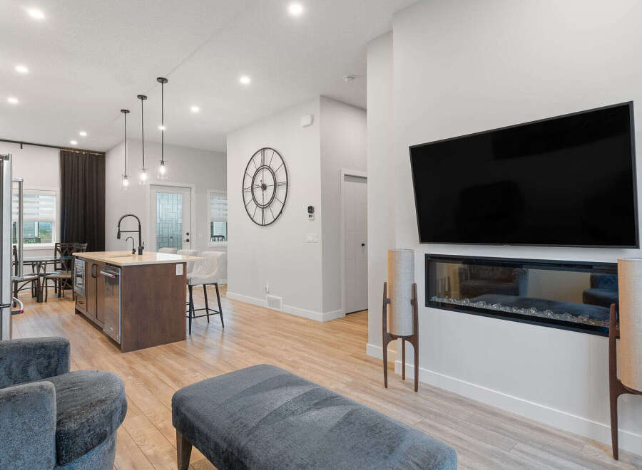 Experience modern living in this open-concept home featuring a sleek kitchen island with pendant lighting and bar seating.