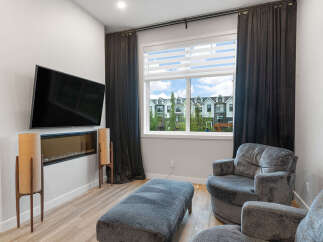 Experience modern living in this stylish living room, featuring a sleek wall-mounted television above a contemporary fireplace.
