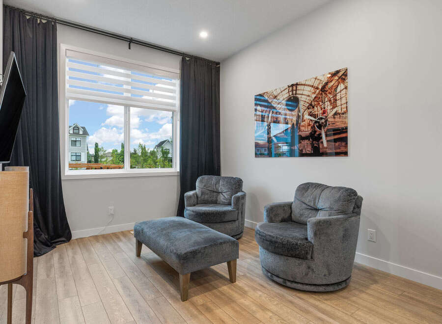 Experience comfort and style in this inviting living space, featuring plush grey armchairs and an ottoman perfect for relaxation.