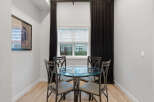 This dining area features a stylish glass-top table with four upholstered chairs, perfect for intimate meals.