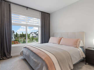 Experience comfort and style in this beautifully appointed bedroom, featuring a plush upholstered headboard and soft, inviting bedding.