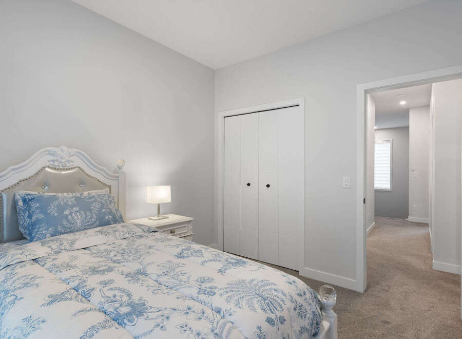 Step into this charming bedroom featuring a plush white bed with elegant blue floral bedding.
