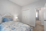 Step into this charming bedroom featuring a plush white bed with elegant blue floral bedding.