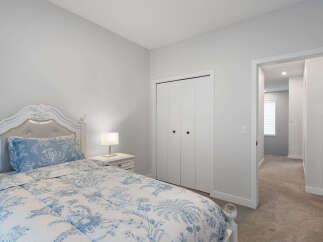 Step into this charming bedroom featuring a plush white bed with elegant blue floral bedding.