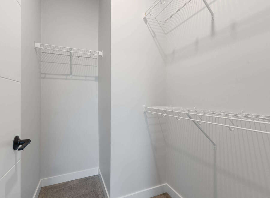 Discover ample storage solutions in this spacious walk-in closet, featuring versatile wire shelving on multiple walls.