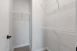 Discover ample storage solutions in this spacious walk-in closet, featuring versatile wire shelving on multiple walls.