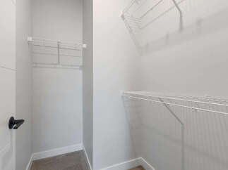 Discover ample storage solutions in this spacious walk-in closet, featuring versatile wire shelving on multiple walls.