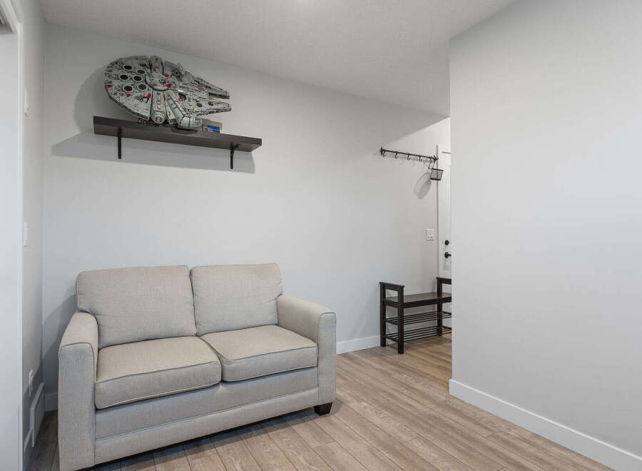This entryway features a comfortable light-colored sofa, perfect for a quick rest or putting on shoes.