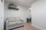 This entryway features a comfortable light-colored sofa, perfect for a quick rest or putting on shoes.
