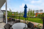 Enjoy outdoor living on this charming patio, complete with a glass-top table and comfortable wicker chairs, perfect for al fresco dining.