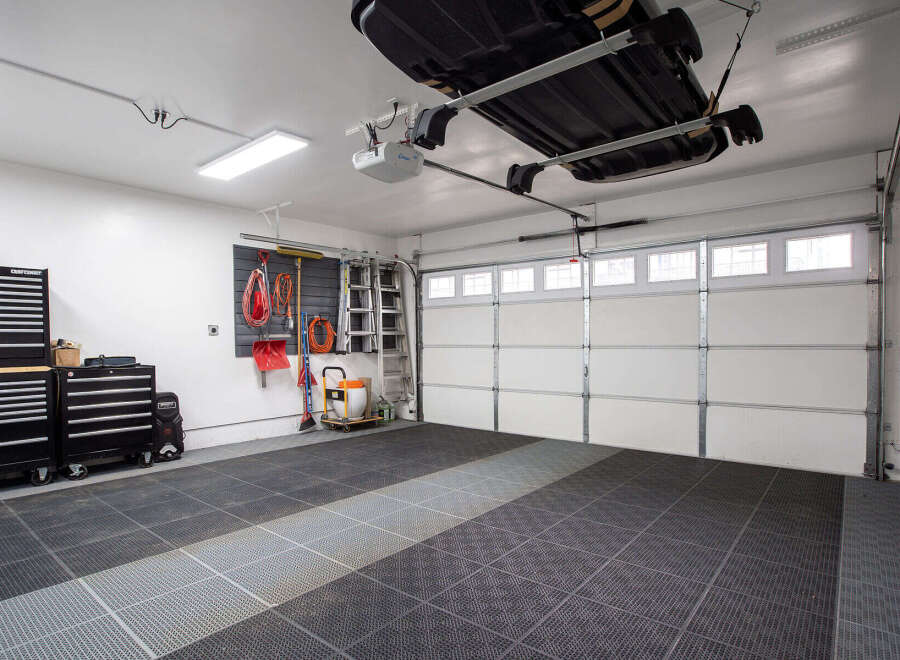 This spacious garage features a durable interlocking tile floor, perfect for protecting your vehicles and providing a clean workspace.
