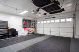 This spacious garage features a durable interlocking tile floor, perfect for protecting your vehicles and providing a clean workspace.