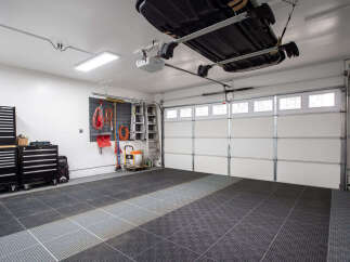 This spacious garage features a durable interlocking tile floor, perfect for protecting your vehicles and providing a clean workspace.
