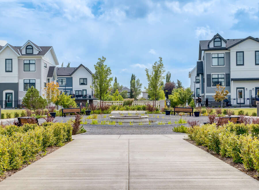 Discover modern living in this stunning townhome community, featuring a beautifully landscaped central courtyard with a water feature and ample seating.