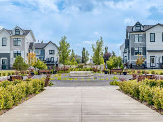 Discover modern living in this stunning townhome community, featuring a beautifully landscaped central courtyard with a water feature and ample seating.