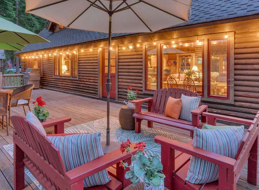 Experience the ultimate mountain retreat with this charming log cabin's expansive deck, perfect for outdoor entertaining.