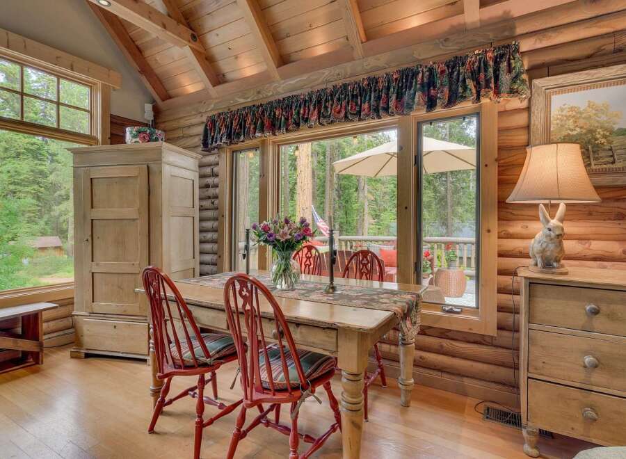 Experience rustic charm in this cozy dining area, featuring a wooden table with red chairs perfect for intimate meals.