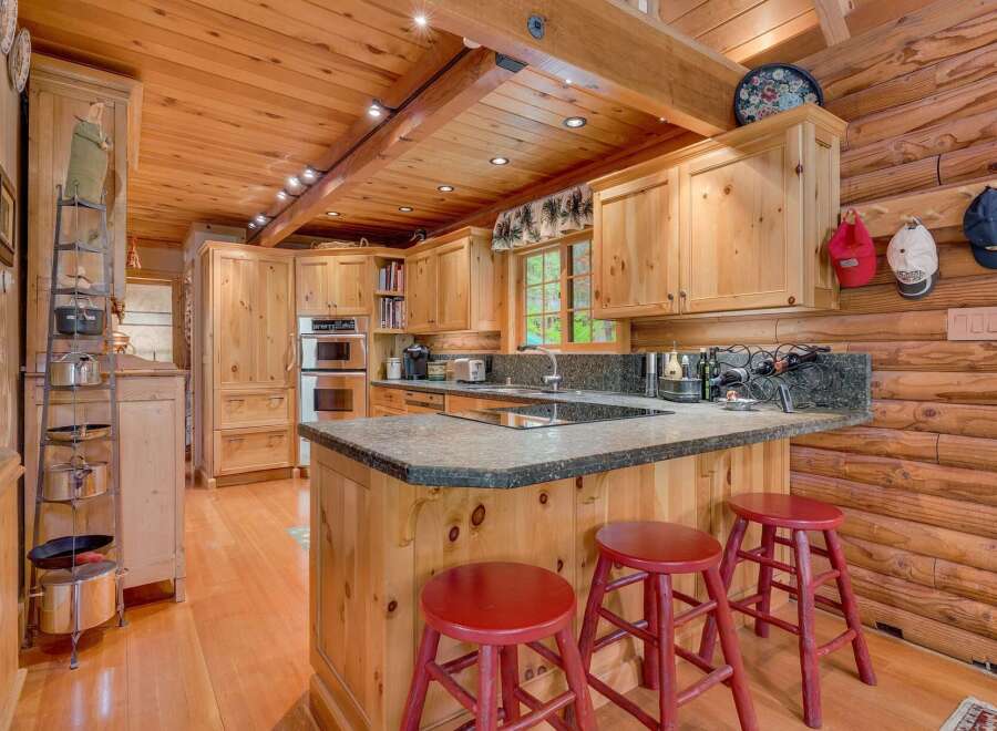 Experience rustic charm in this log cabin kitchen, featuring warm wood cabinetry and exposed beams.