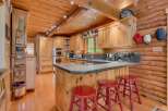 Experience rustic charm in this log cabin kitchen, featuring warm wood cabinetry and exposed beams.