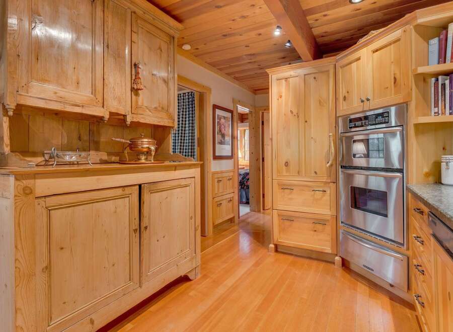 Experience rustic charm in this beautifully appointed kitchen featuring custom knotty pine cabinetry throughout.