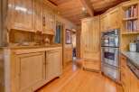 Experience rustic charm in this beautifully appointed kitchen featuring custom knotty pine cabinetry throughout.