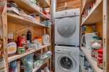 Discover ample storage solutions in this pantry, featuring well-organized shelves stocked with pantry essentials and cleaning supplies.