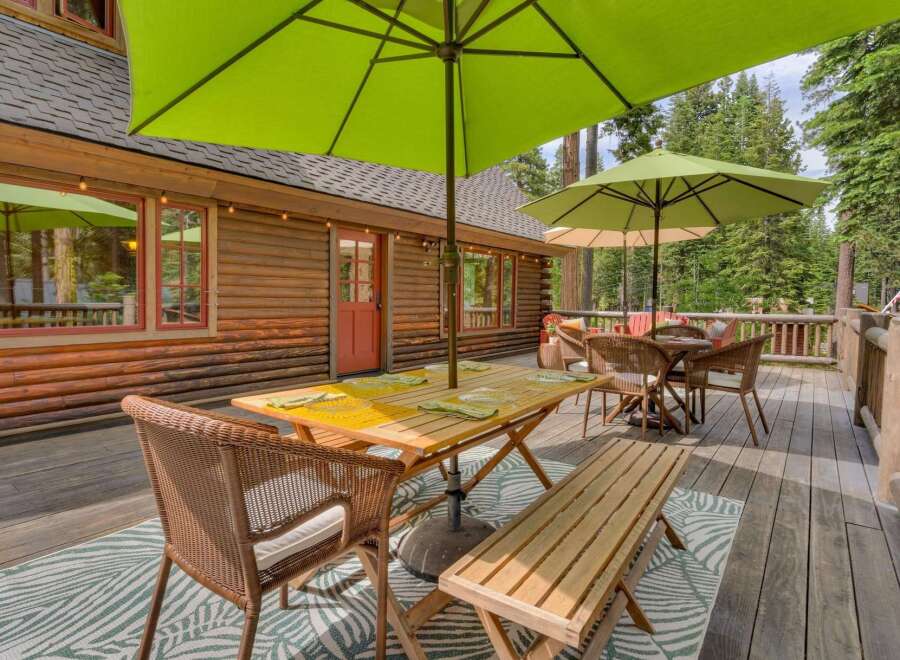 Enjoy outdoor living on this spacious wooden deck, perfect for entertaining or relaxing amidst a serene forest setting.
