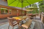 Enjoy outdoor living on this spacious wooden deck, perfect for entertaining or relaxing amidst a serene forest setting.