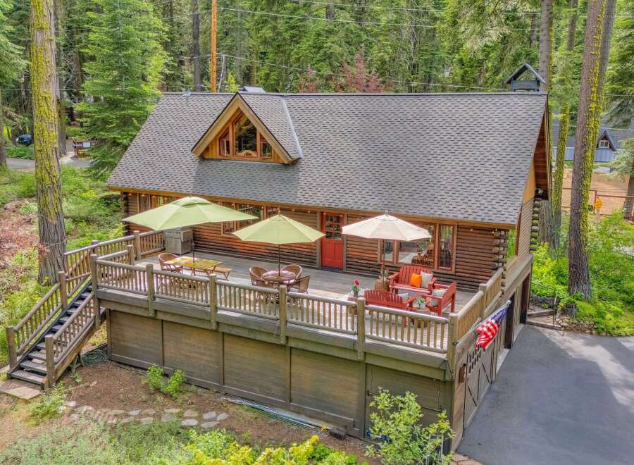 Experience rustic charm and outdoor living at this beautiful log cabin, featuring a spacious deck perfect for entertaining or relaxing amidst the serene forest setting.