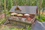 Experience rustic charm and outdoor living at this beautiful log cabin, featuring a spacious deck perfect for entertaining or relaxing amidst the serene forest setting.