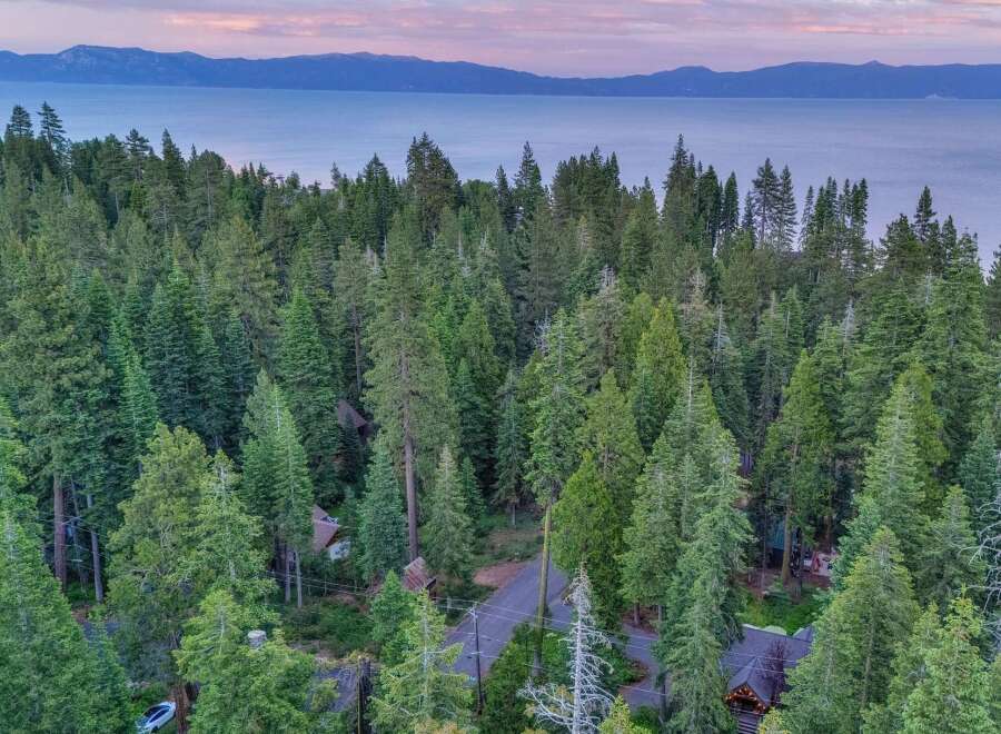 Nestled amidst a lush pine forest, this property offers a serene escape with breathtaking views of a distant lake and mountains.