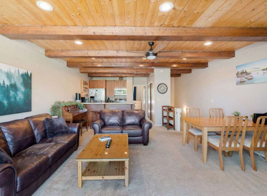 Experience rustic charm in this open-concept living space, featuring a stunning wood-beamed ceiling and exposed wooden beams that add warmth and character.