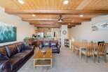 Experience rustic charm in this open-concept living space, featuring a stunning wood-beamed ceiling and exposed wooden beams that add warmth and character.