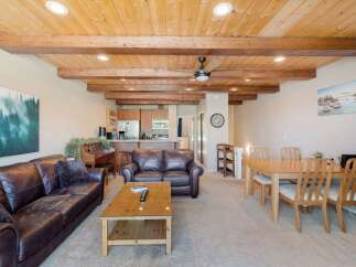 Experience rustic charm in this open-concept living space, featuring a stunning wood-beamed ceiling and exposed wooden beams that add warmth and character.