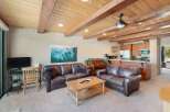Experience rustic charm in this inviting living space featuring rich leather sofas and a warm, wood-paneled ceiling with exposed beams.