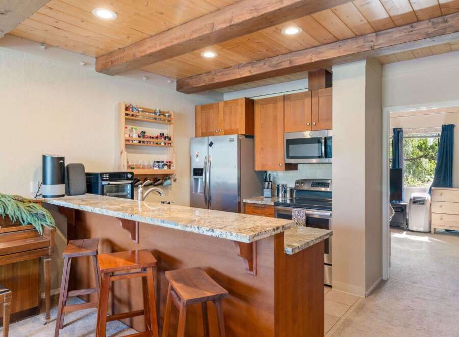 Experience the charm of this kitchen featuring warm wood cabinetry and a granite-topped breakfast bar, perfect for casual dining.