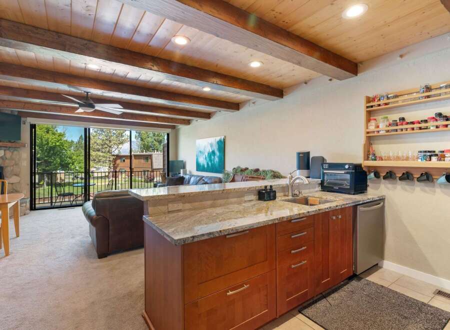 Experience comfortable living in this inviting space featuring a well-equipped kitchenette with ample cabinet storage and a granite countertop.