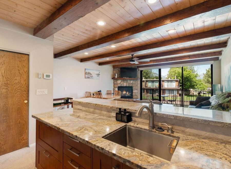 Experience rustic charm and modern comfort in this stunning property featuring a vaulted wood-beamed ceiling and a cozy stone fireplace.