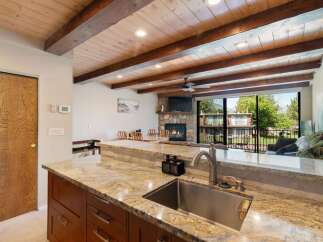 Experience rustic charm and modern comfort in this stunning property featuring a vaulted wood-beamed ceiling and a cozy stone fireplace.