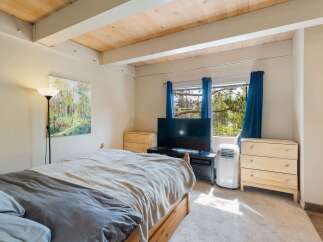 This inviting bedroom features a comfortable bed adorned with cozy linens, perfect for a restful night's sleep.