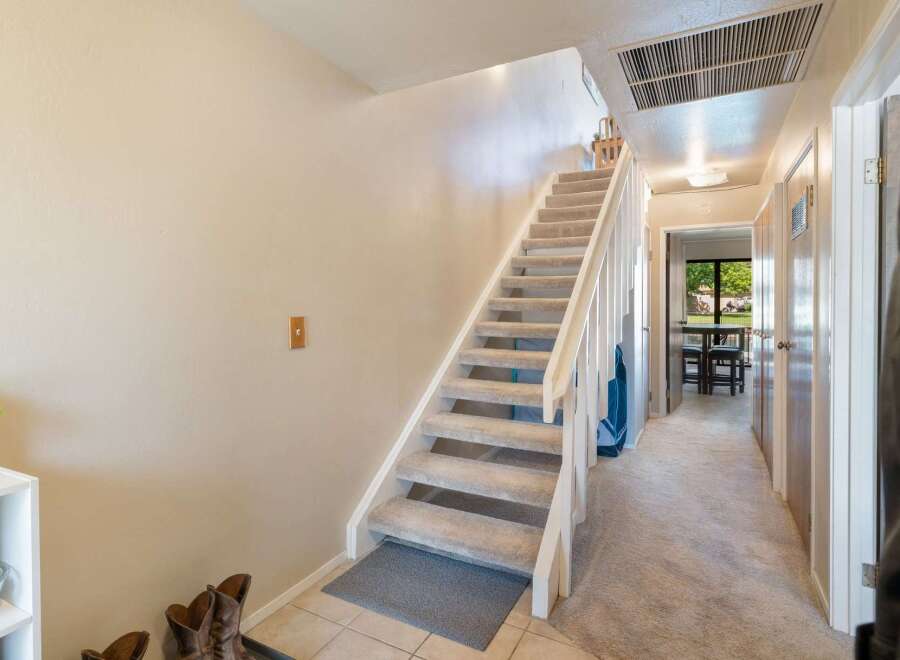 Discover comfortable living in this charming home featuring a carpeted staircase leading to the upper level.