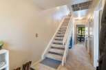 Discover comfortable living in this charming home featuring a carpeted staircase leading to the upper level.