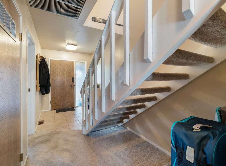 Step into this welcoming entryway featuring a convenient coat rack and a sturdy wooden front door.