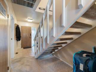 Step into this welcoming entryway featuring a convenient coat rack and a sturdy wooden front door.