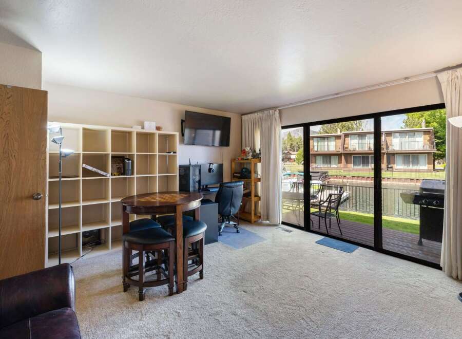 Enjoy stunning waterfront living in this spacious room featuring a large entertainment area with a gaming table and a dedicated workspace.
