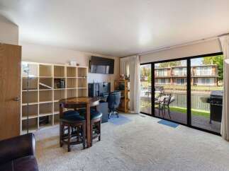 Enjoy stunning waterfront living in this spacious room featuring a large entertainment area with a gaming table and a dedicated workspace.